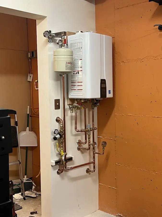 Plumbing technician inspecting water heater connections in Lake Providence